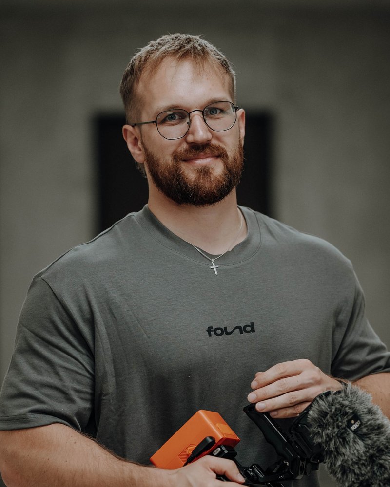 Michael, Videoexperte im Support-Team von Found Studios mit Videokamera und Mikrofon